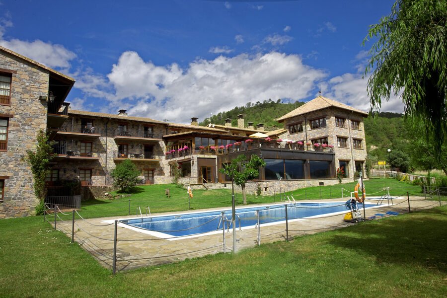 Hotel Peña Montañesa: fachada de piedra y piscina exterior con vistas al Pirineo